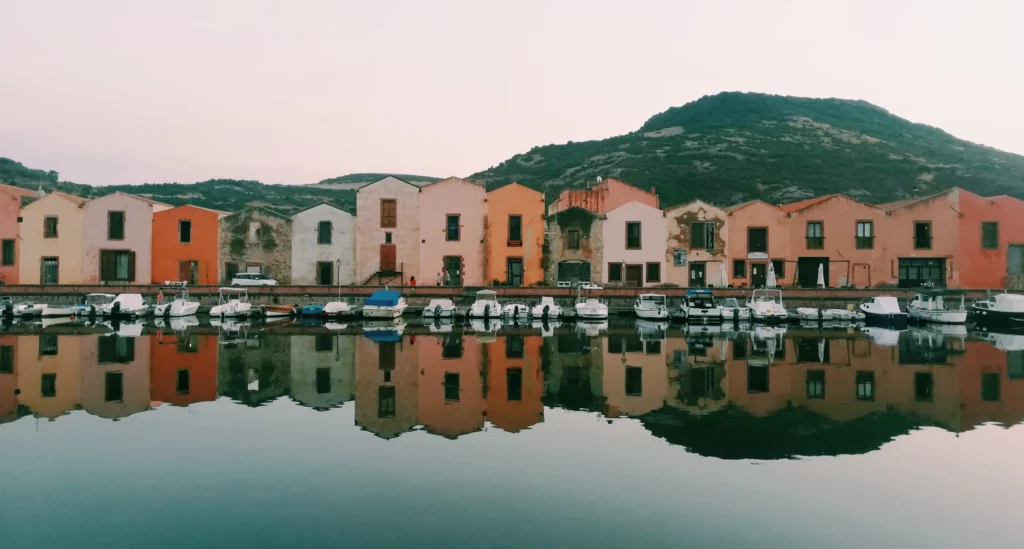 Case rurali in riva con delle barche ormeggiate - Rural houses on the shore with moored boats © Foto di Lachezara Parvanova on Unsplash